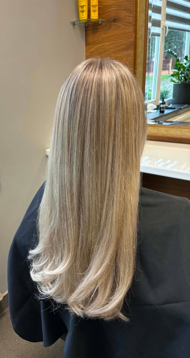 Długie proste włosy w chłodnym blondzie po koloryzacji i modelowaniu